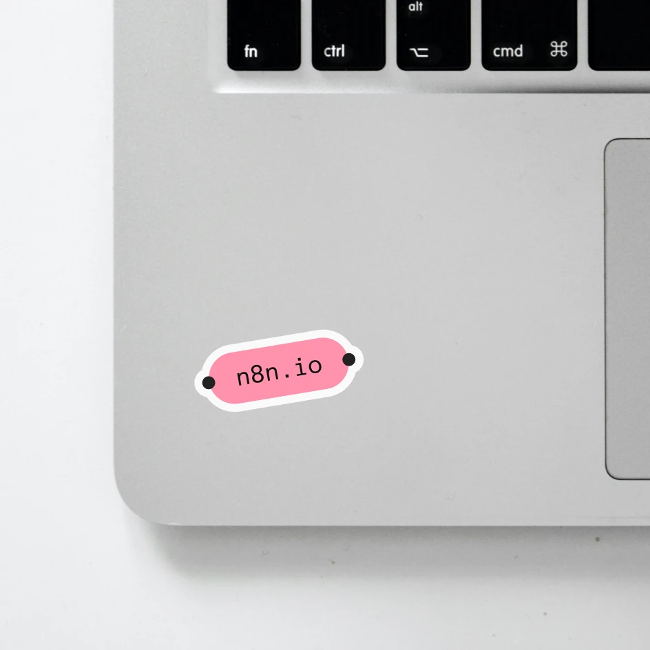 An n8n.io capsule sticker on a laptop next to the keyboard