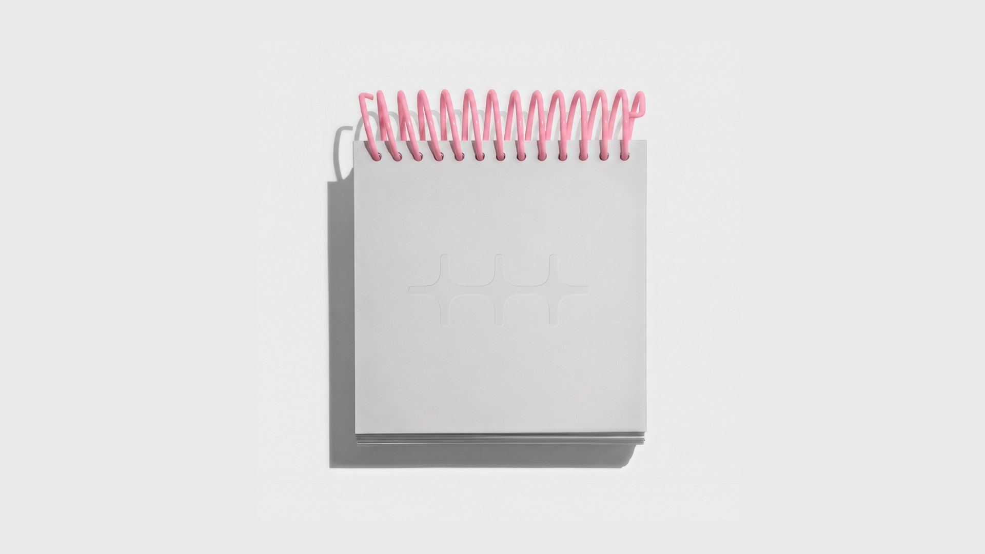 Gray spiral notebook with a pink coil and the n8n symbol debossed on the cover