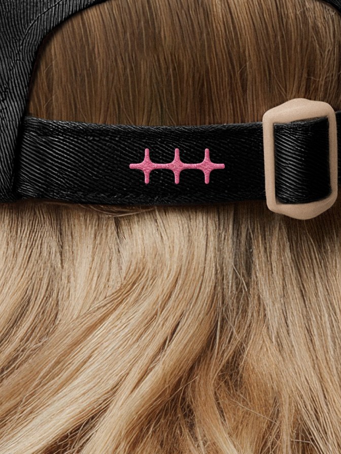 Pink n8n symbol embroidered on the strap of a black cap