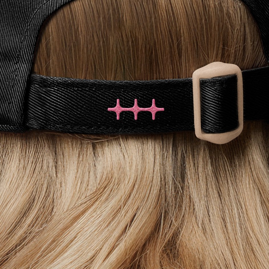 Pink n8n symbol embroidered on the back strap of a black cap